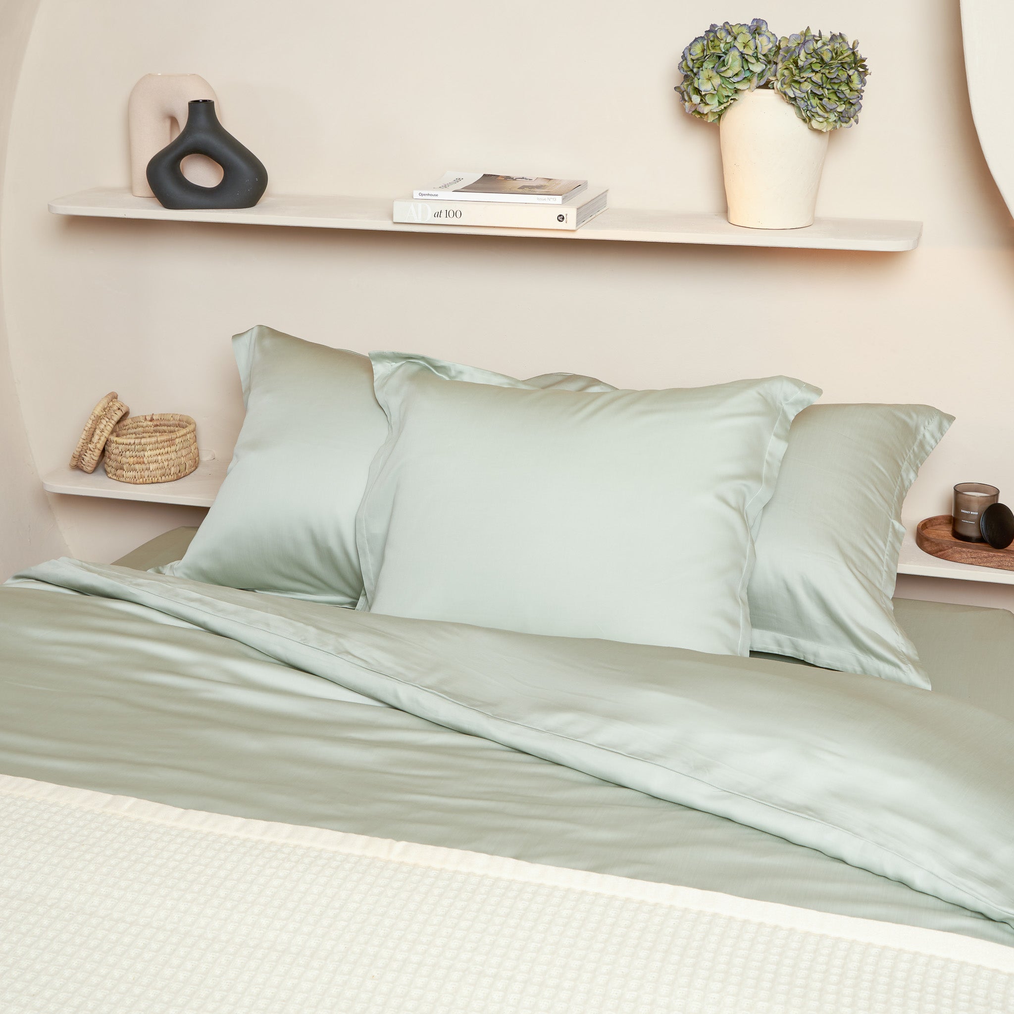 Opgemaakt bed met drie grote Tencel kussenslopen in de kleur groen grijs