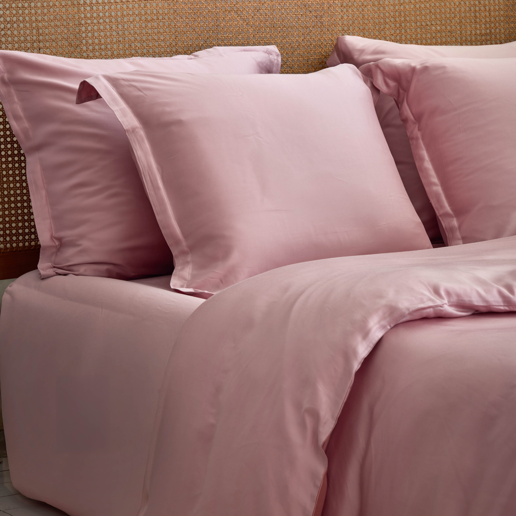 Mauve hoeslaken om matras met kussenslopen erop