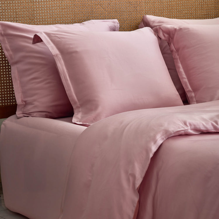 Mauve hoeslaken om matras met kussenslopen erop