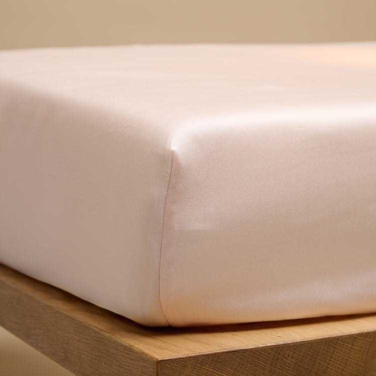 Een hoeslaken van TENCEL™ Sateen, ook wel lyocell, om een matras in de kleur Perzik Wit 