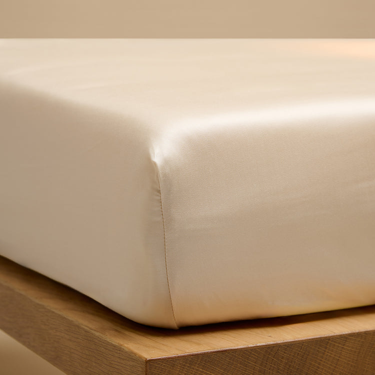 Een hoeslaken van TENCEL™ Sateen, ook wel lyocell, om een matras in de kleur Wit Zand. 