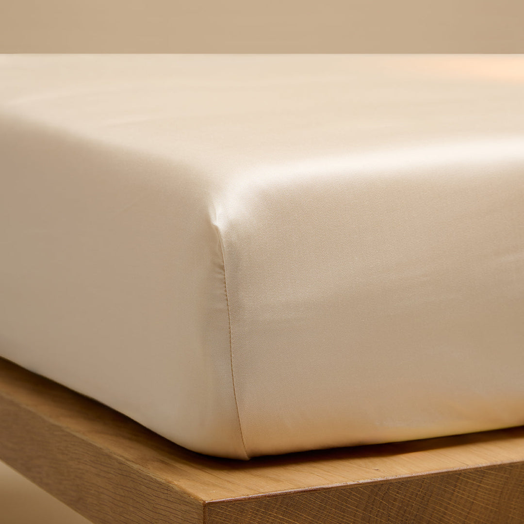 Een hoeslaken van TENCEL™ Sateen, ook wel lyocell, om een matras in de kleur Wit Zand. 