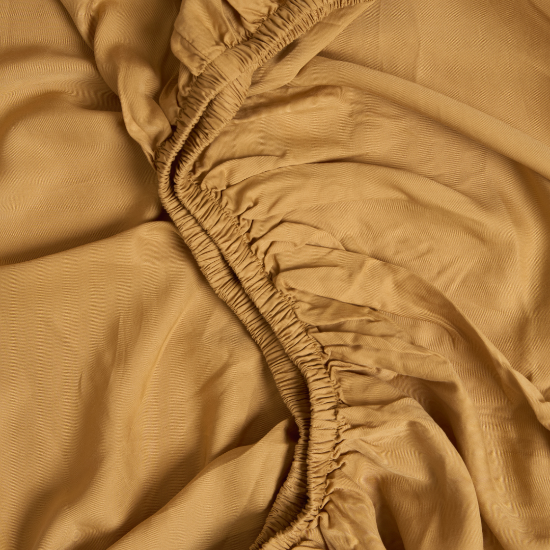 De elastieken van een hoeslaken TENCEL Twill in de kleur Okergeel