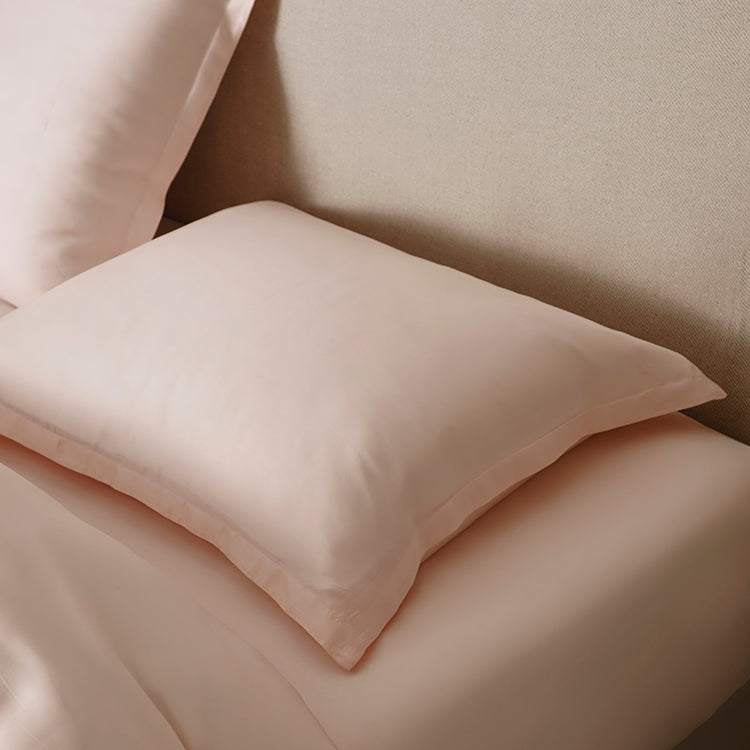 100% TENCEL Kussensloop  in kleur Perzik Wit op bed