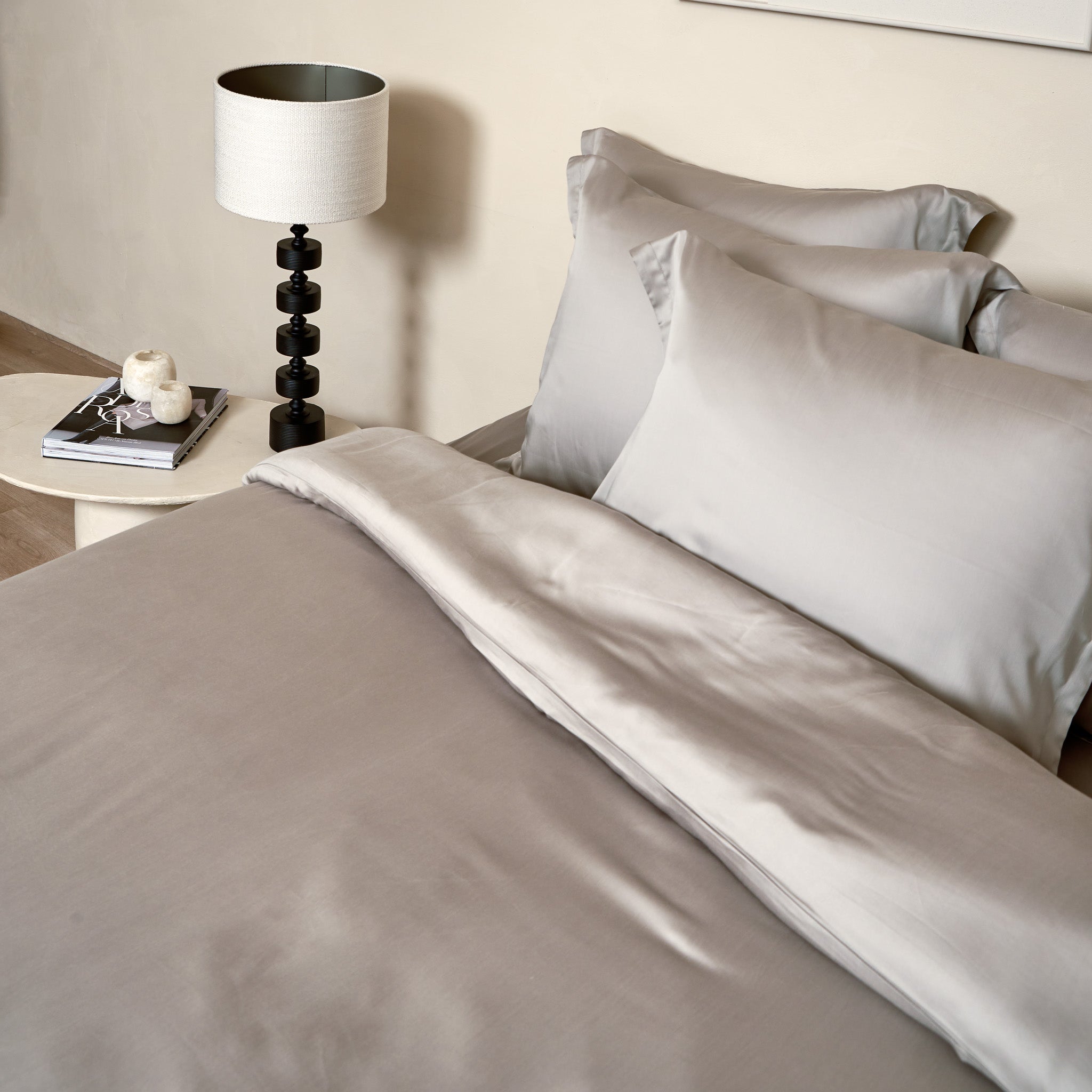 Opgemaakt bed met kussenslopen en dekbedovertrek in de kleur taupe van de stof Tencel