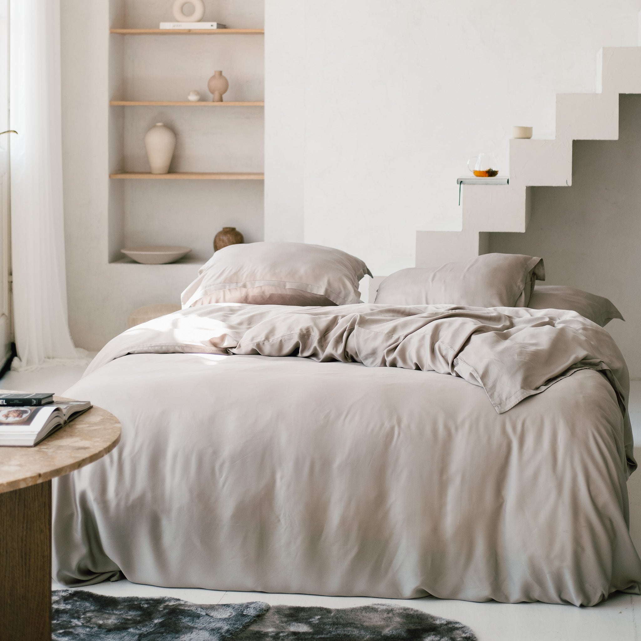 Slaapkamer met opgemaakt bed met dekbedovertrek in de kleur taupe gemaakt van de stof Tencel 