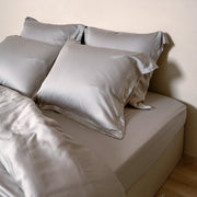 Opgemaakt bed met vier kussenslopen in de kleur taupe van de stof tencel