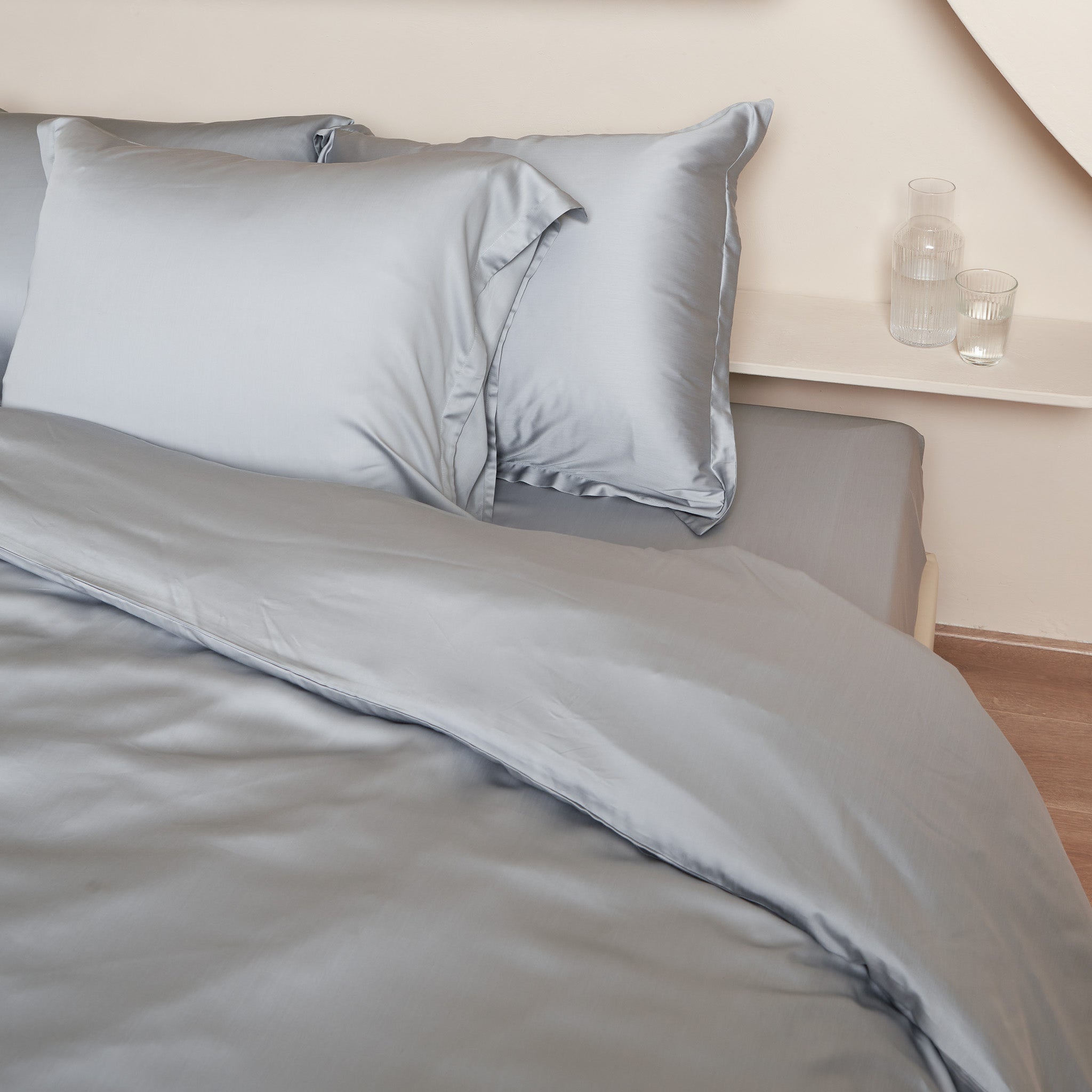 Opgemaakt bed met hoeslaken, dekbedovertrek en kussenslopen