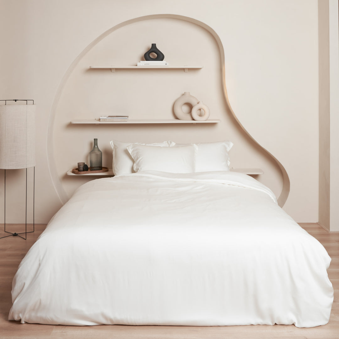 Slaapkamer met opgemaakt bed van Tencel beddengoed in de kleur off white.