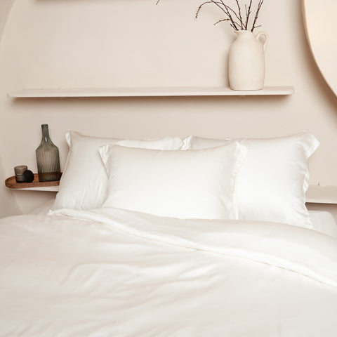 Mooi opgemaakt bed van Tencel beddengoed met drie kussenslopen in de kleur off white