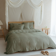 Slaapkamer met opgemaakt bed in de kleur olijfgroen. Het beddengoed is van de natuurlijke stof bamboe die heerlijk zacht voelt.
